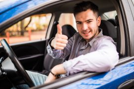Happy man sitting in a van showing thumbs up